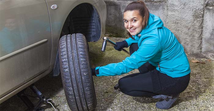 Woman changes tire